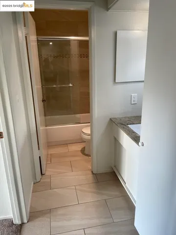 a bathroom with a granite countertop sink a toilet and a mirror