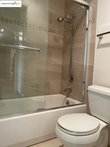 a white toilet and tub sitting next to a bathroom sink