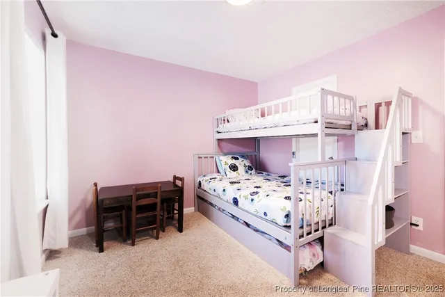 a bed sitting in a bedroom next to a window with a baby crib