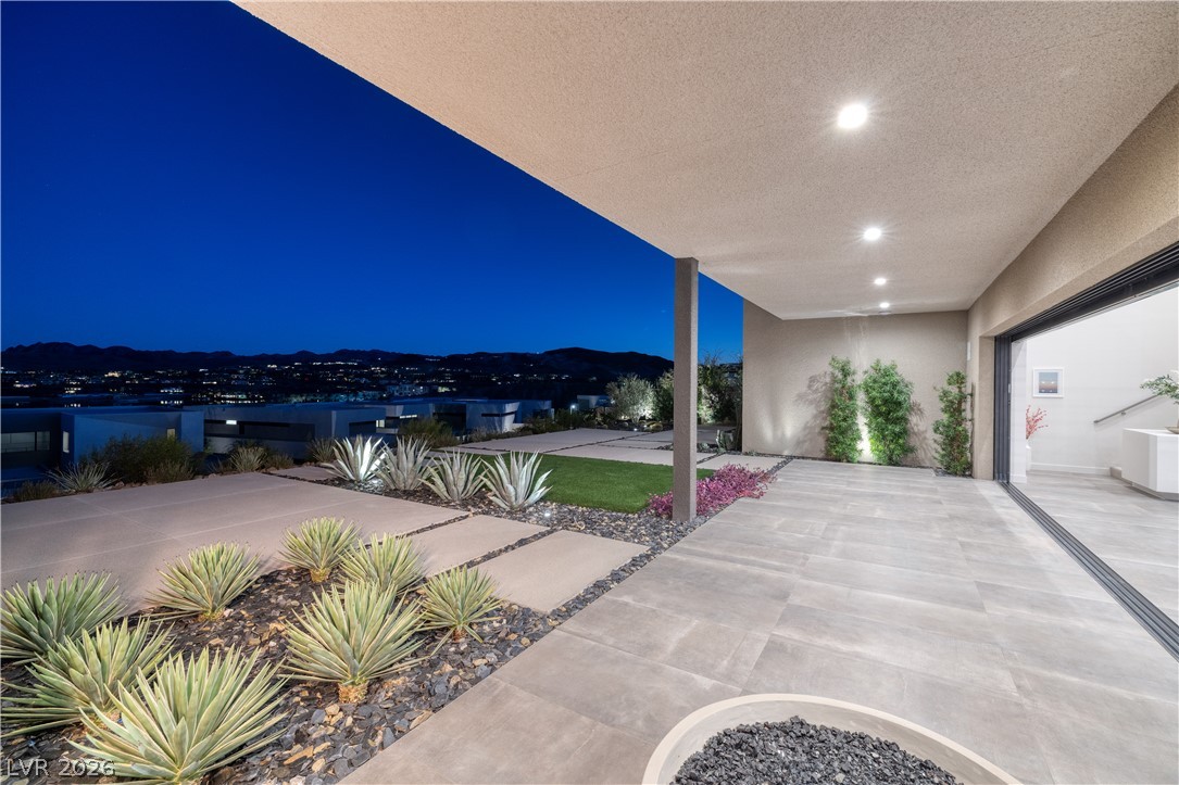 25 Falling Ridge Lane Henderson, NV 89011 - Photo 14 of 48 An inviting outdoor patio at dusk provides a beautiful vista of the city lights.