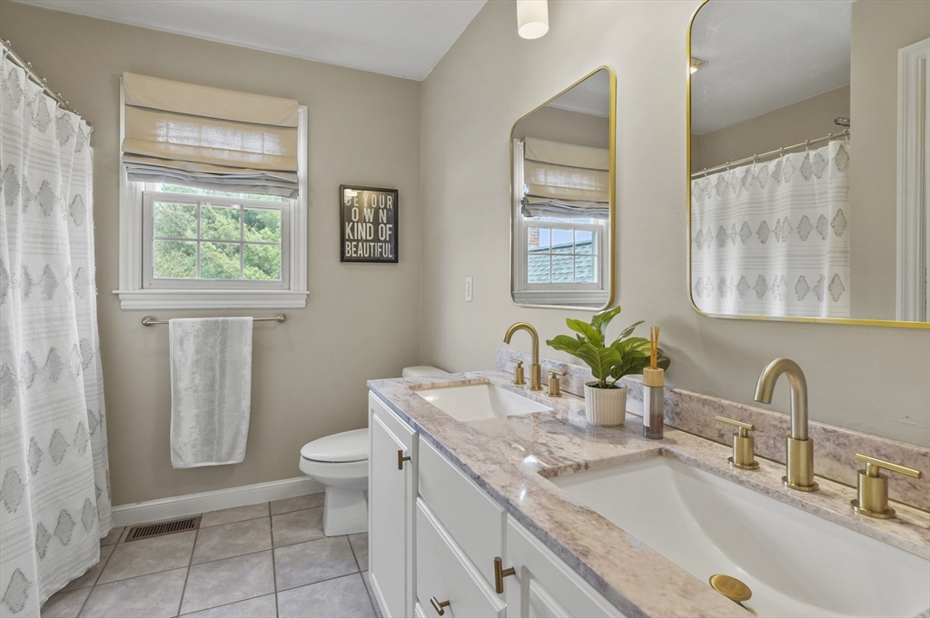 12 Peach Tree Drive Sutton, MA 01590 - Photo 30 of 37 a bathroom with a granite countertop toilet a sink a mirror a window and vanity