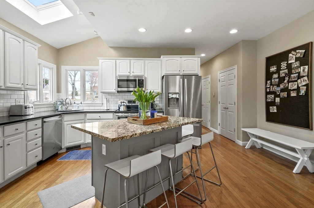 12 Peach Tree Drive Sutton, MA 01590 - Photo 6 of 37 a kitchen with stainless steel appliances granite countertop a refrigerator a sink dishwasher a stove and white cabinets with wooden floor