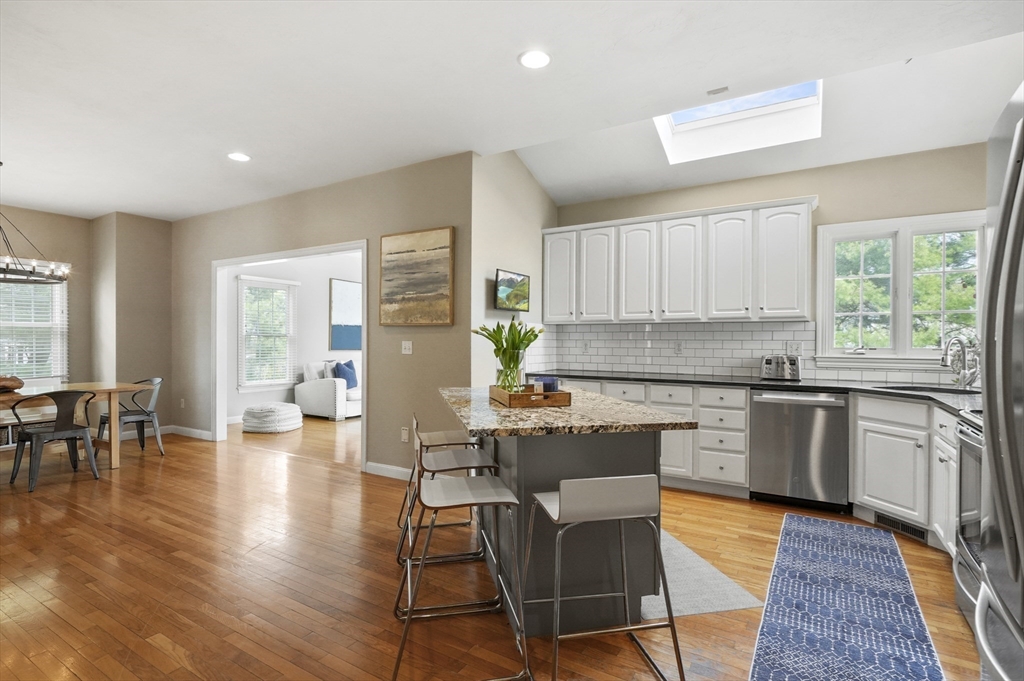 12 Peach Tree Drive Sutton, MA 01590 - Photo 8 of 37 a kitchen with stainless steel appliances granite countertop wooden floor a dining table and chairs