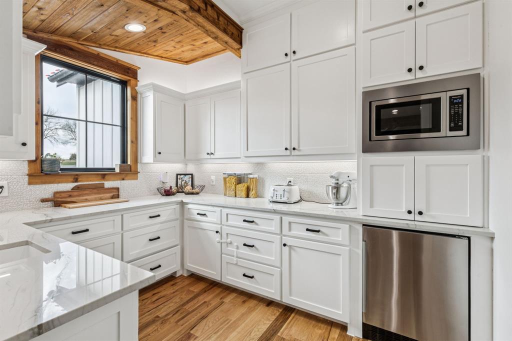 2577 Lone Star Road Celina, TX 75009 - Photo 7 of 40 a kitchen with stainless steel appliances white cabinets and a window