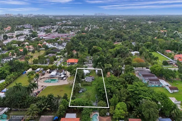 an aerial view of residential houses with outdoor space and trees