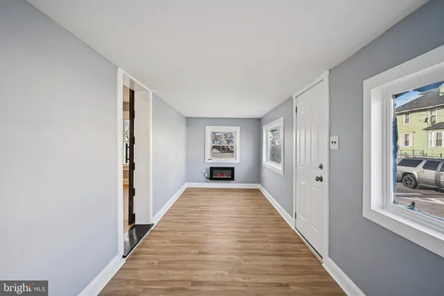 a view of a hallway with wooden floor and windows