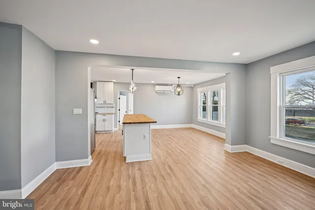 a kitchen with stainless steel appliances kitchen island granite countertop a sink a stove a refrigerator and island with wooden floor