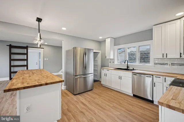 an empty room with wooden floor fireplace and windows