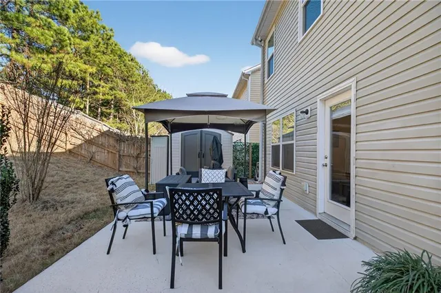 a backyard of a house with table and chairs