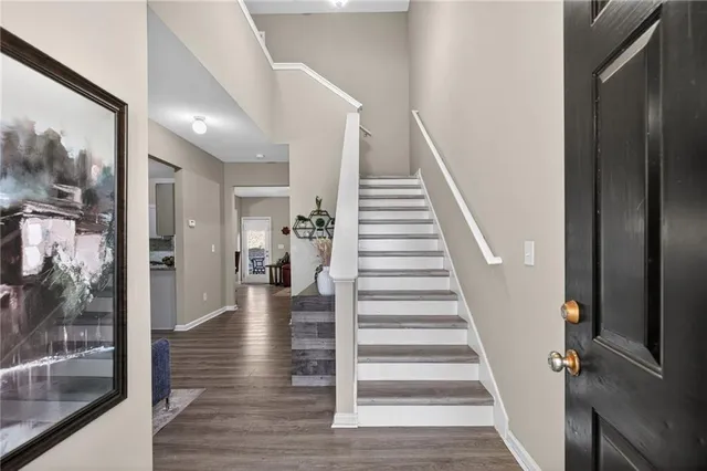 a view of a hallway with wooden floor and staircase
