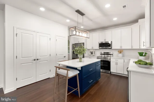 a kitchen with kitchen island granite countertop a sink cabinets and wooden floor