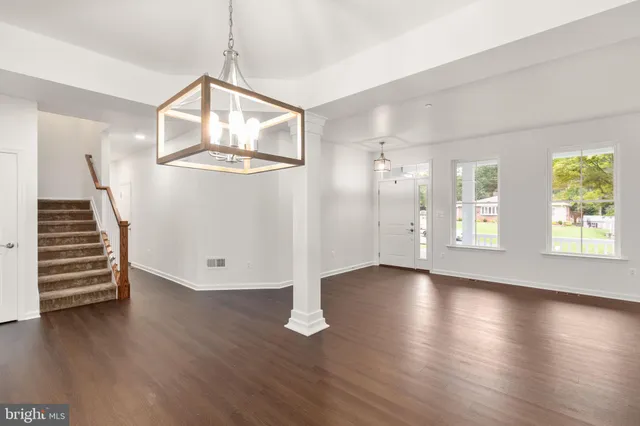 an empty space with wooden floors and stairs