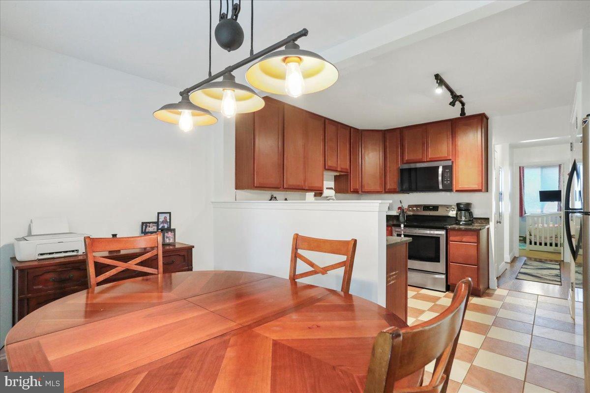 501 Prospect Boulevard Frederick, MD 21701 - Photo 17 of 27 a kitchen with stainless steel appliances a stove a refrigerator and a dining table