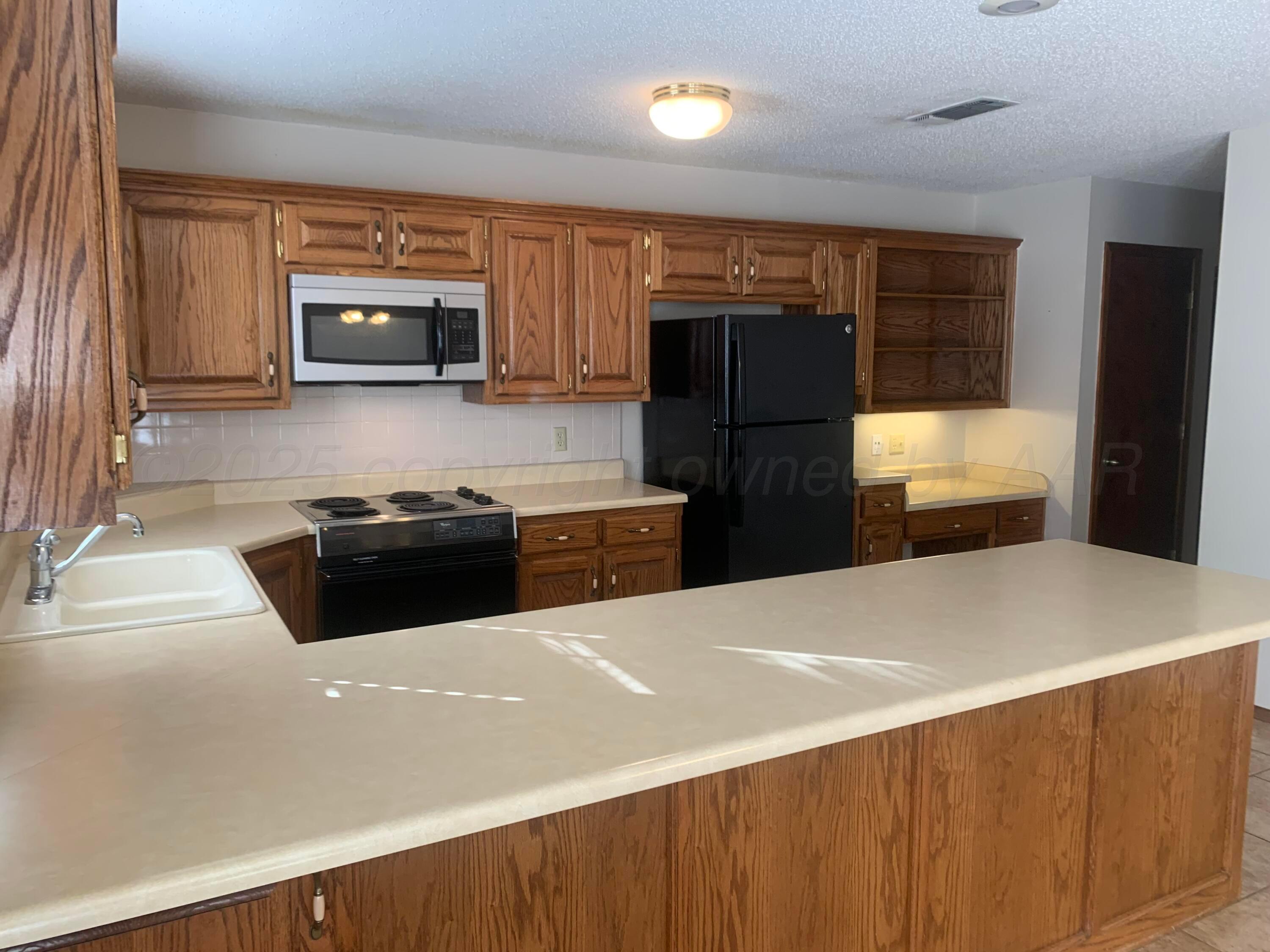 901 7th Street Canyon, TX 79015 - Photo 4 of 9 a kitchen with stainless steel appliances a refrigerator and a stove top oven
