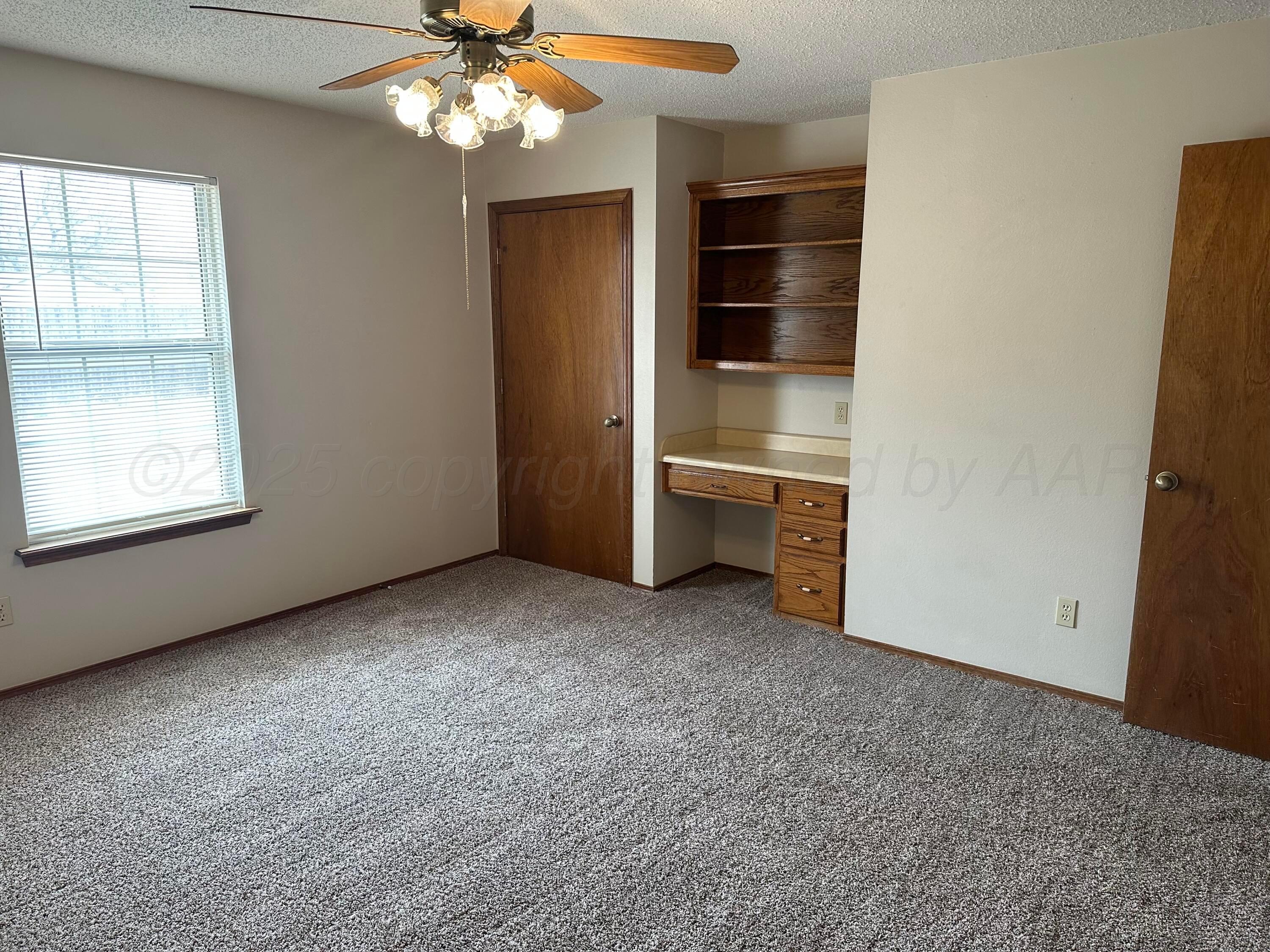 901 7th Street Canyon, TX 79015 - Photo 8 of 9 an empty room with chandelier fan and windows