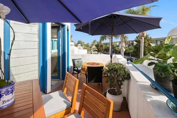 a view of a patio with table and chairs under an umbrella