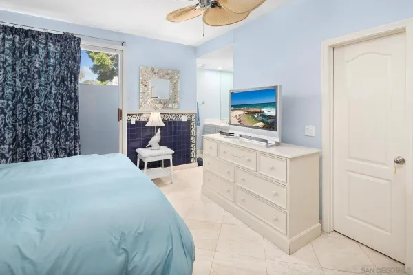 a bedroom with a bed and a flat tv screen on dresser