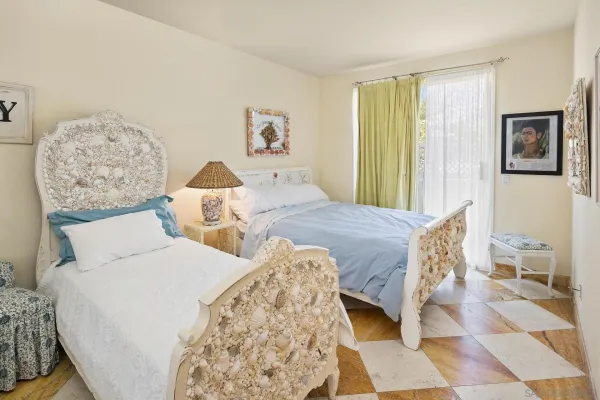 a bedroom with two beds and painting on the wall