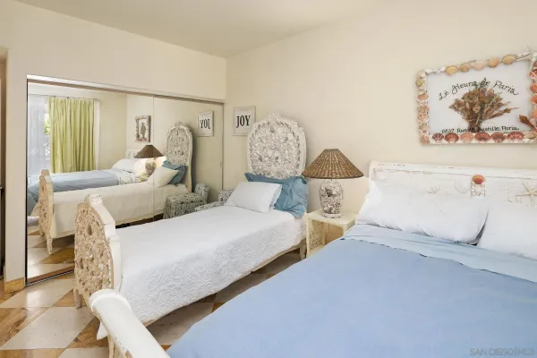 a bedroom with two beds and painting on the wall