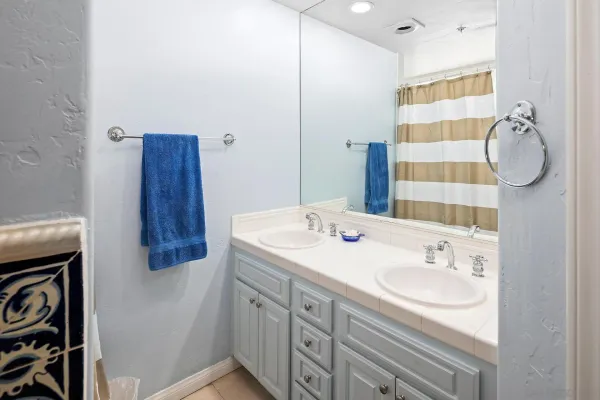 a bathroom with a granite countertop sink and a mirror