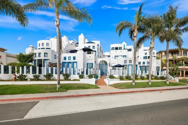 a front view of multiple houses with yard and green space