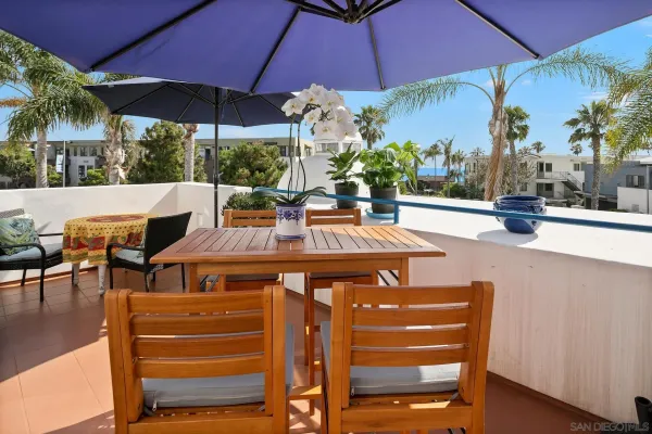 a view of a patio with table and chairs under an umbrella