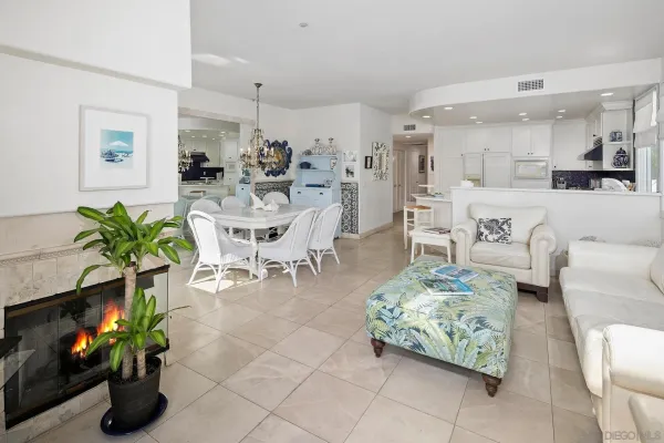 a living room with furniture potted plant and kitchen view