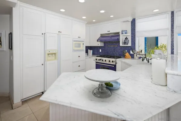 a kitchen with stainless steel appliances kitchen island granite countertop a refrigerator and a sink