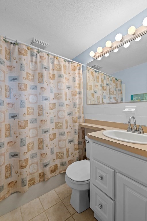 27 Norwood Avenue, Unit 2 Manchester, MA 01944 - Photo 10 of 17 a bathroom with a granite countertop toilet a sink a mirror and a shower