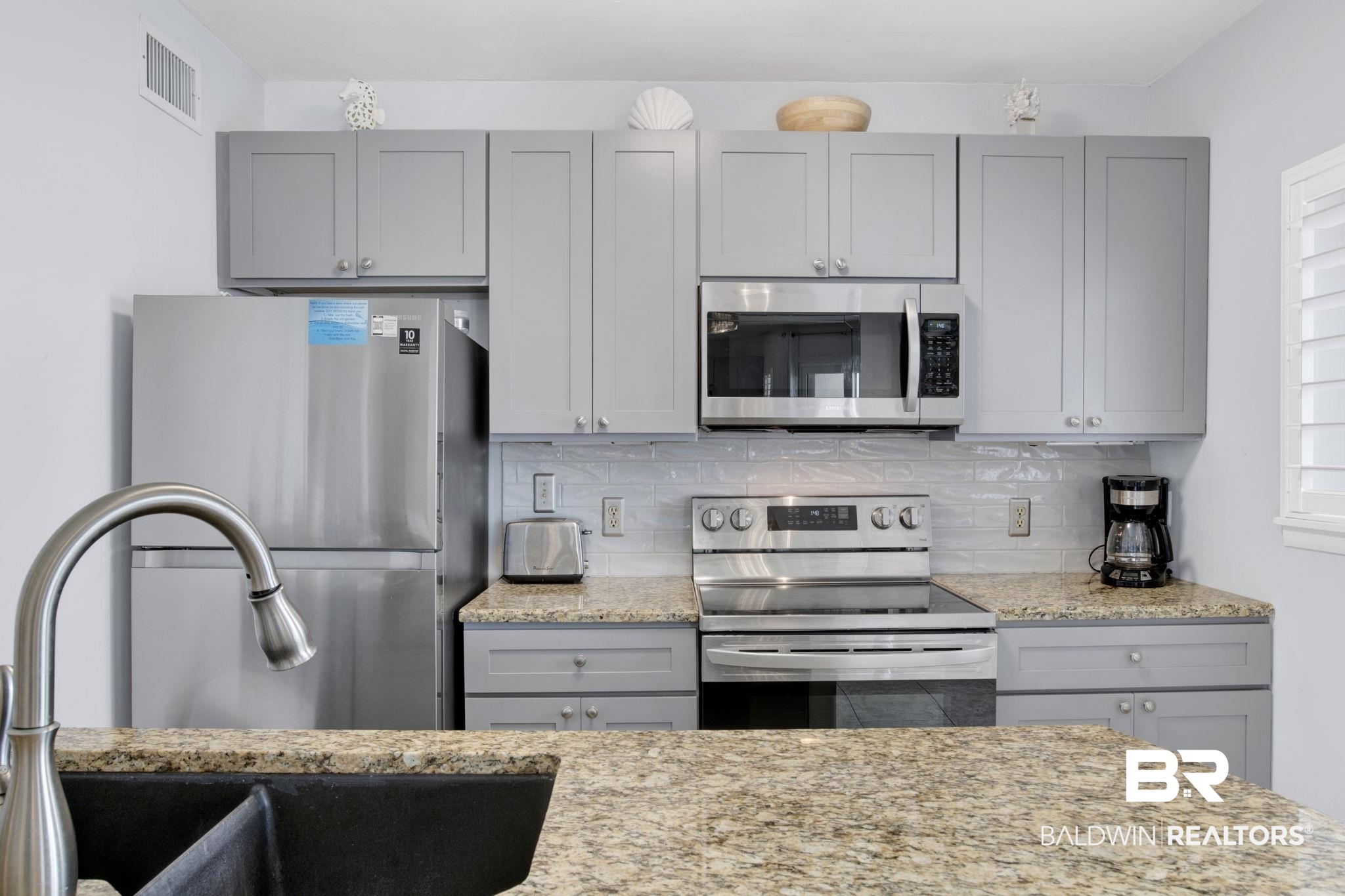 375 Plantation Road, Unit 5514 Gulf Shores, AL 36542 - Photo 18 of 44 Kitchen featuring stainless steel appliances, gray cabinetry, and decorative backsplash