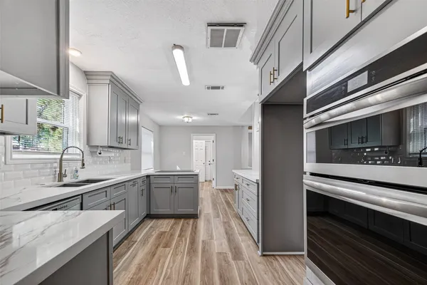 a kitchen with stainless steel appliances granite countertop a sink and cabinets