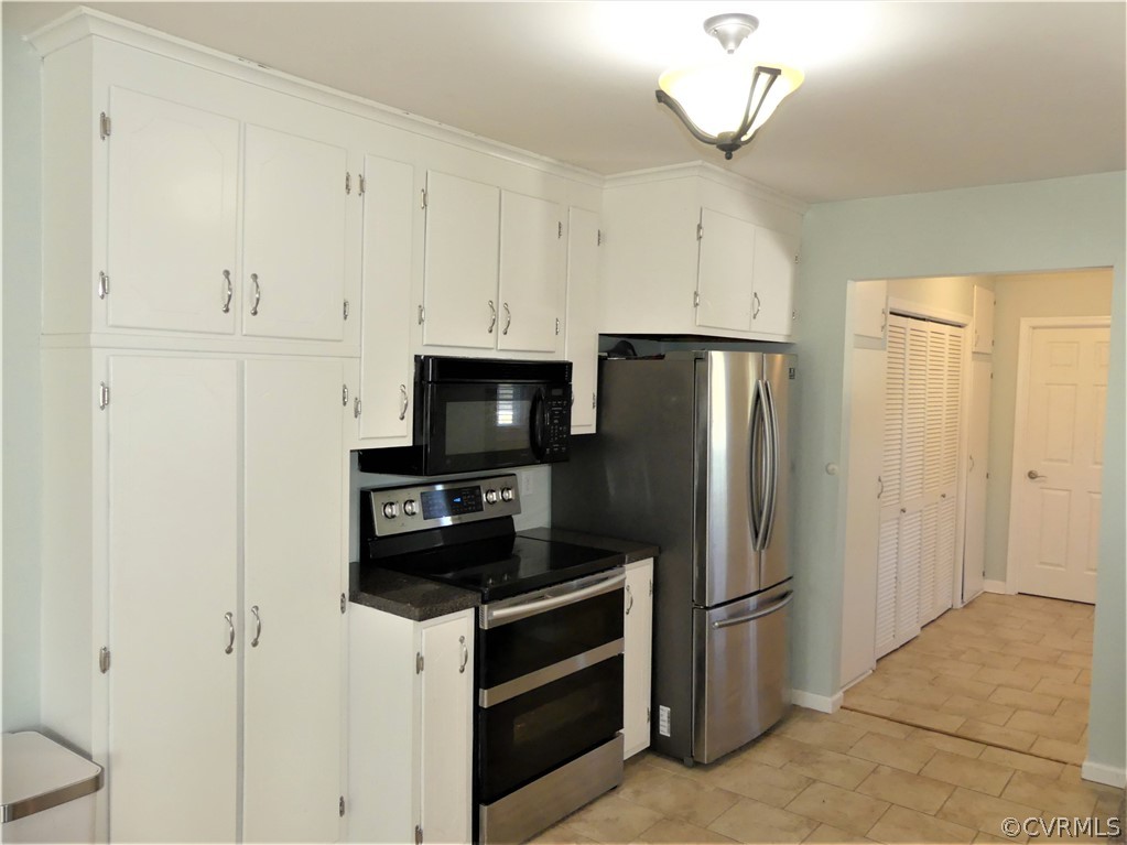 1325 Courthouse Road Chase City, VA 23924 - Photo 19 of 49 a kitchen with stainless steel appliances a refrigerator a stove a microwave and cabinets