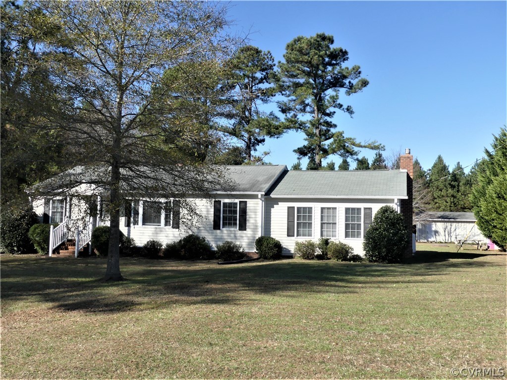 1325 Courthouse Road Chase City, VA 23924 - Photo 2 of 49 a front view of a house with a garden and trees