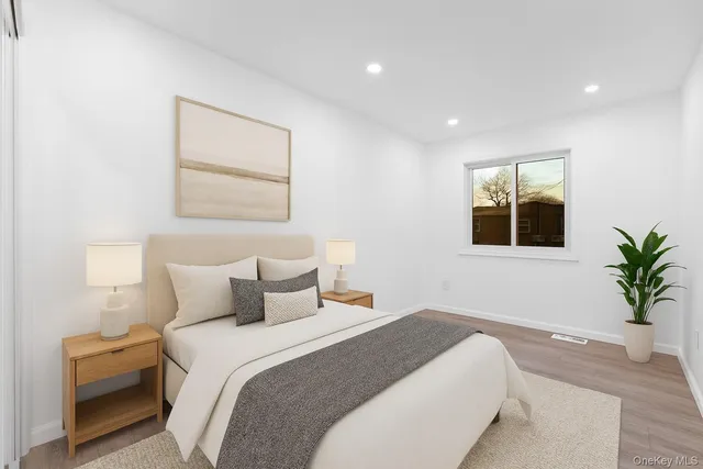 a bedroom with a large bed and a potted plant