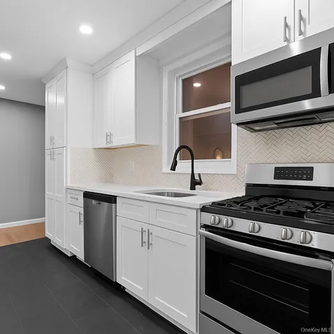 a kitchen with stainless steel appliances a stove a microwave and cabinets