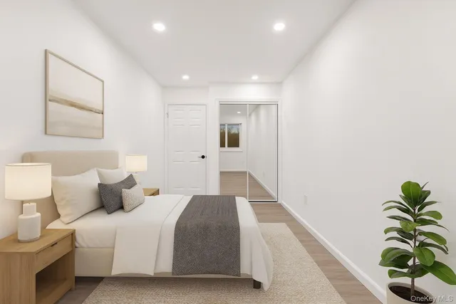 a spacious bedroom with a bed and a potted plant