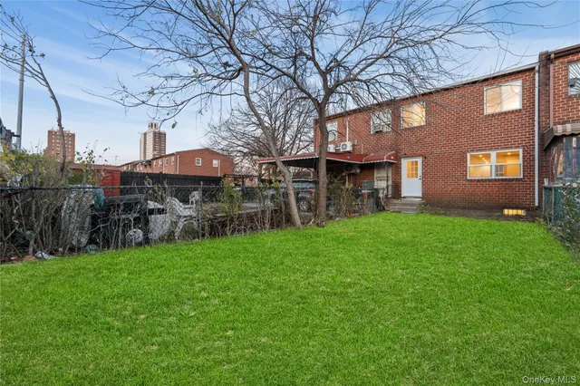 a view of a yard with brick house and a large tree