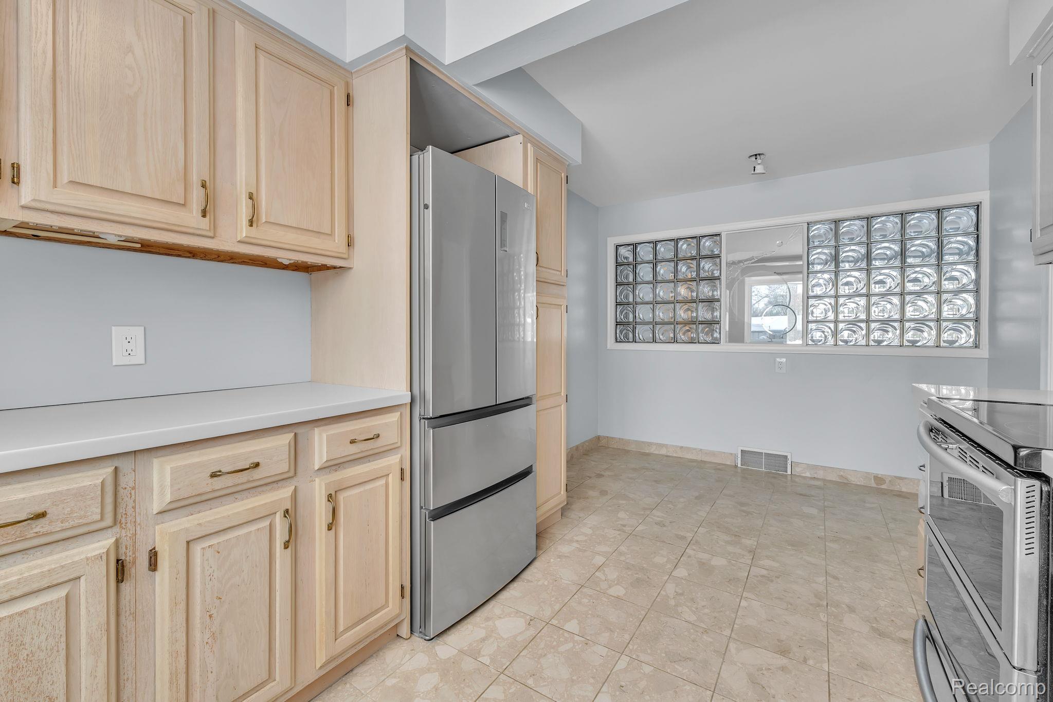 6576 Inkster Road West Bloomfield, MI 48322 - Photo 38 of 62 Kitchen with stainless steel appliances, light countertops, and light brown cabinets