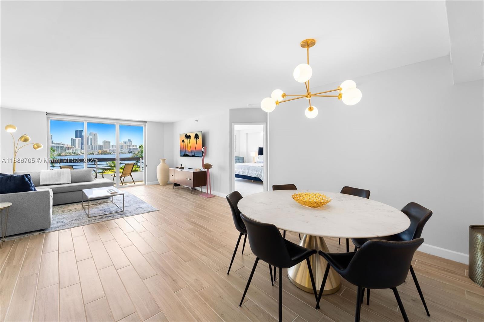 3600 Mystic Pointe Drive, Unit 614 Aventura, FL 33180 - Photo 2 of 14 a view of a dining room with furniture and wooden floor