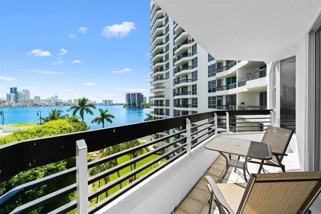 a view of a balcony with chairs and wooden floor