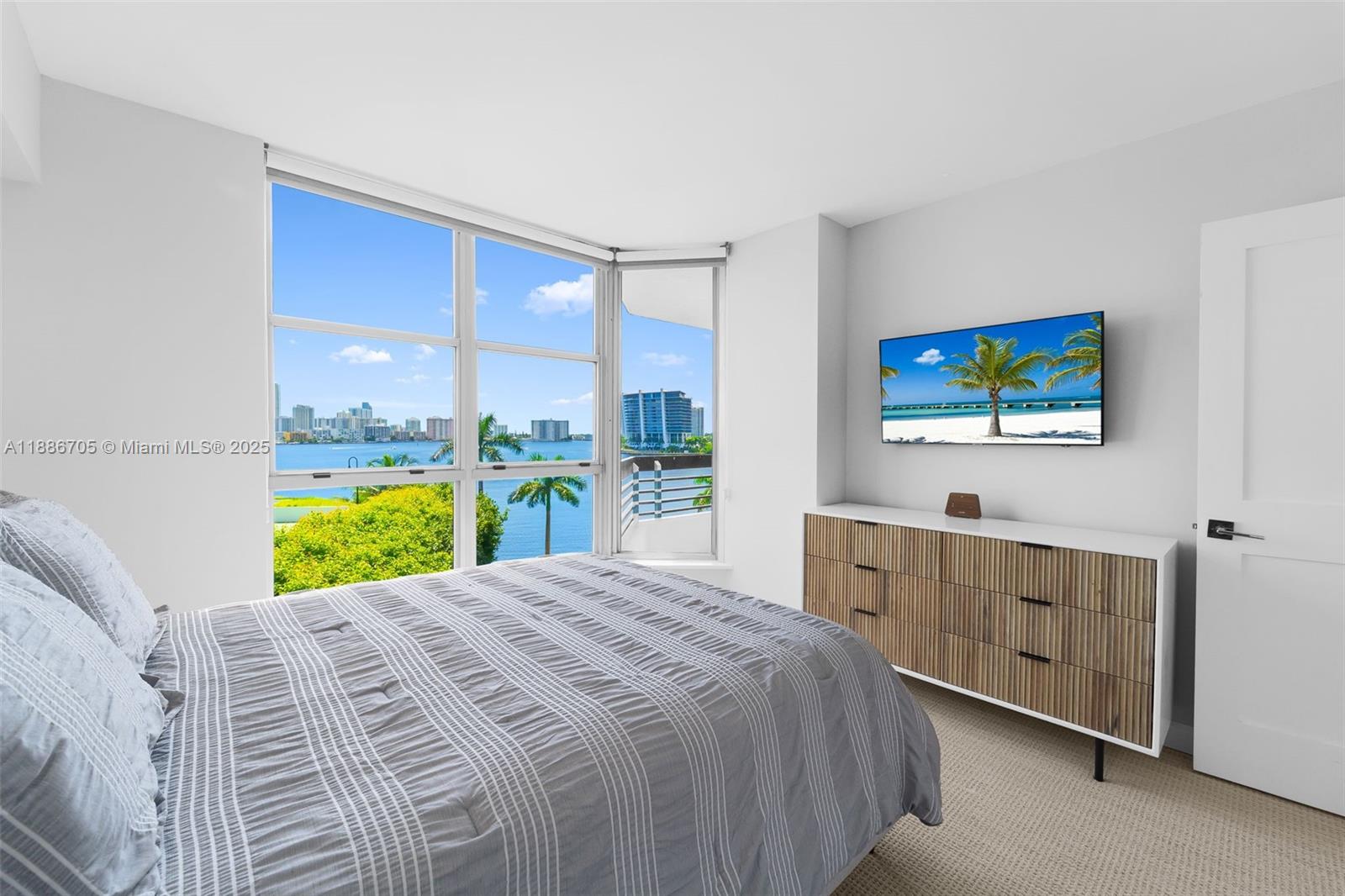 3600 Mystic Pointe Drive, Unit 614 Aventura, FL 33180 - Photo 9 of 14 a bed sitting in a bedroom next to a window