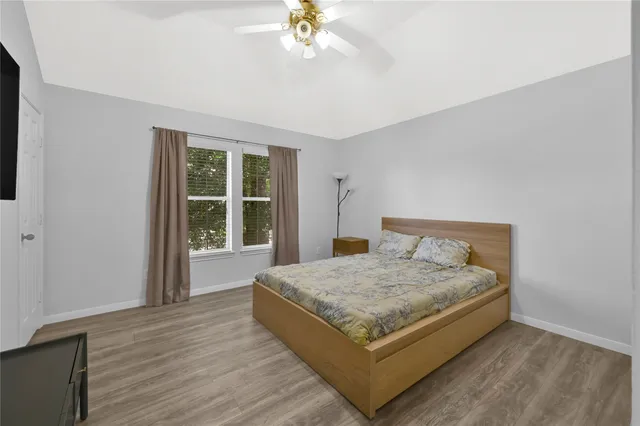 a bed sitting in a spacious bedroom next to a window