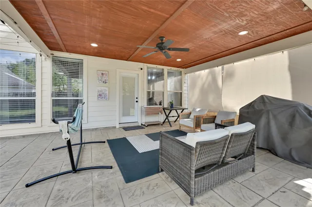 a living room with furniture a flat screen tv and a large window