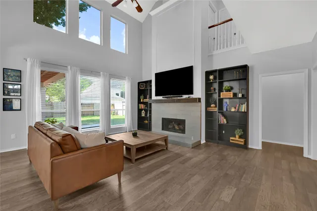 a living room with furniture a flat screen tv and a fireplace