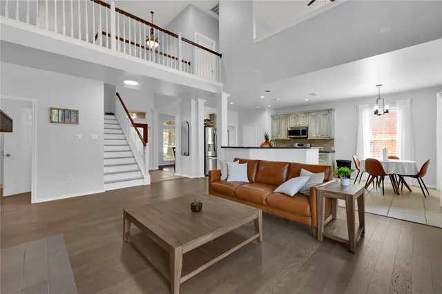 a living room with furniture pool table and wooden floor