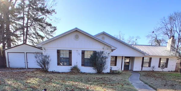 a view of a yard in front of a house with large tree