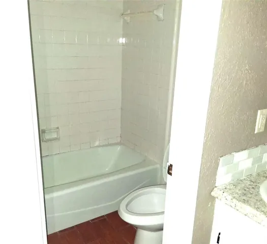 a bathroom with a toilet and a tub