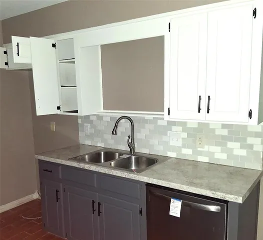 a close view of a sink a mirror and cabinets in a kitchen
