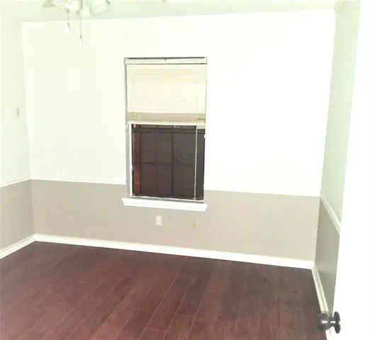 a view of a room with wooden floor and a window