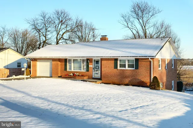 a view of a house with a yard and wooden fence
